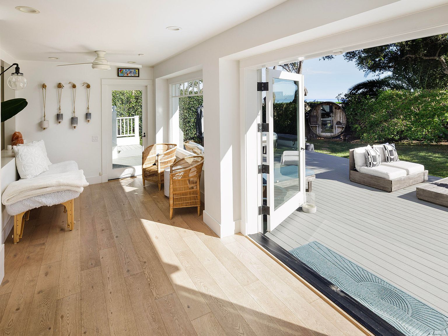 Sun room opening to exterior deck with the ocean horizon beyond